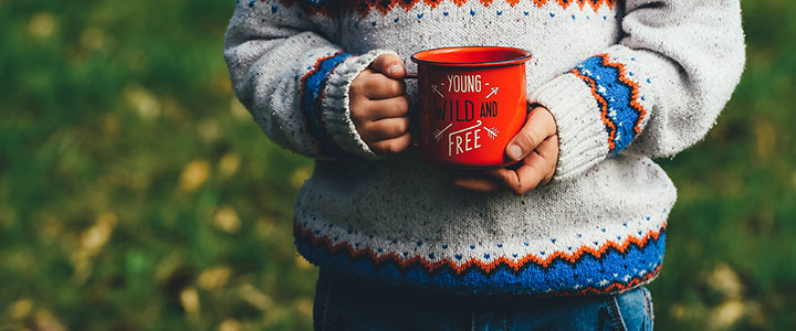 Bild eines Kindes mit Tasse auf der steht "Young, wild and free".